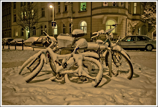 Fahrräder im Schnee im Dunkeln